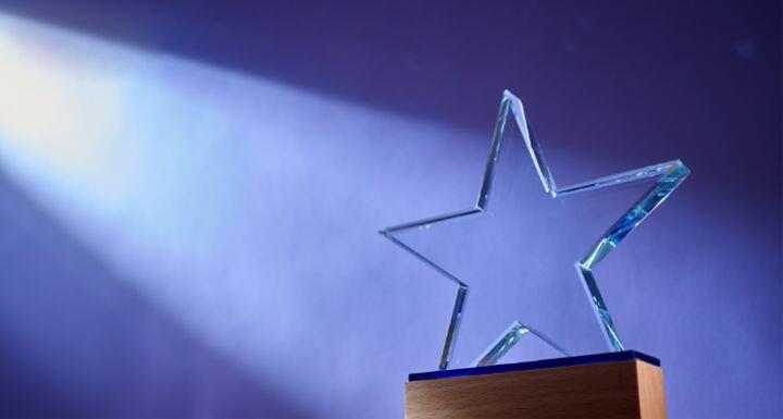 Star shape of crystal trophy against purple background