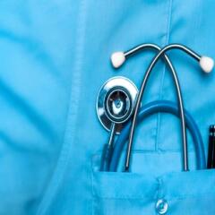 Stethoscope tucked inside of blue scrub pocket