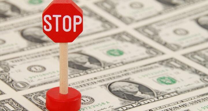 Stop Sign on top of Dollar Bills