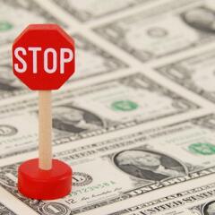 Stop Sign on top of Dollar Bills