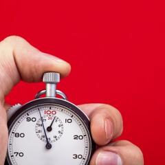 Thumb on stop watch button with red background