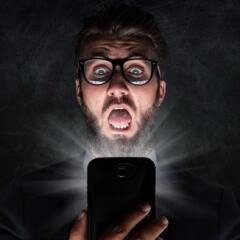 A Surprised man looking a phone