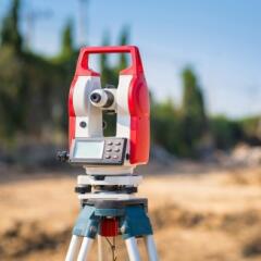 Red and White surveyor's equipment set up on a construction site