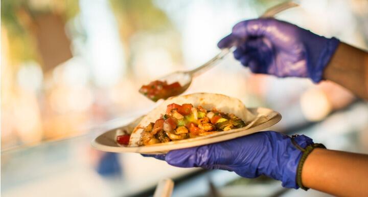 Hands preparing a taco at food truck