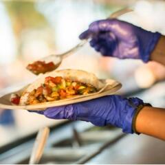 Hands preparing a taco at food truck