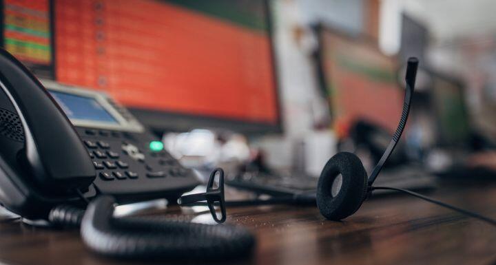 Telephone and headset on desk with computer