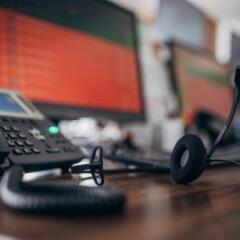 Telephone and headset on desk with computer