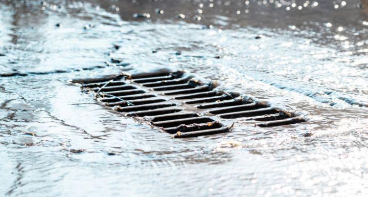 The grate of the storm sewer after the rain