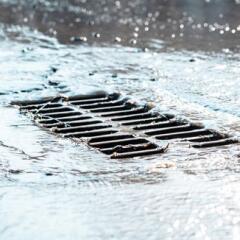 The grate of the storm sewer after the rain