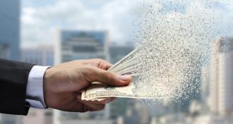 The spread of dollar paper currency in the hand on city background