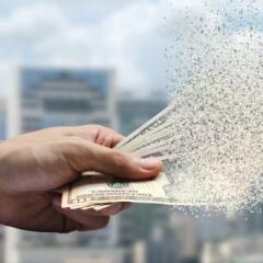 The spread of dollar paper currency in the hand on city background