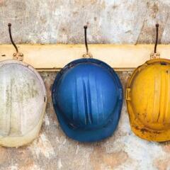 Three construction helmets hanging on a hat-rack