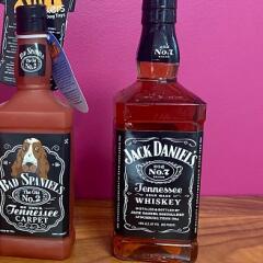 A bottle of Jack Daniels beside dog toy Bad Spaniel's