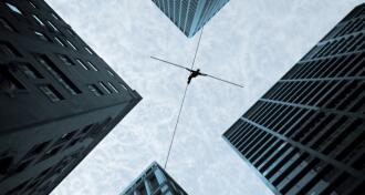 Businessman on tightrope between two offices