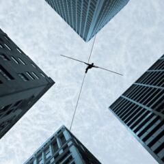 Businessman on tightrope between two offices