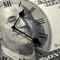 A one hundred dollar bill with a clock face on it.