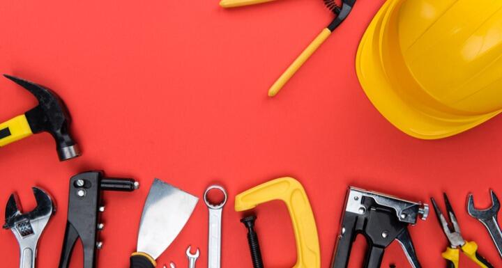 Different Tools and a yellow hard hat on Red Background