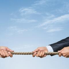 Business people tug of war with rope