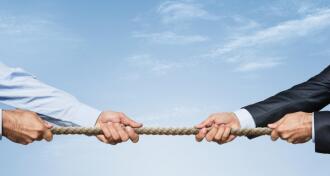 Business people tug of war with rope