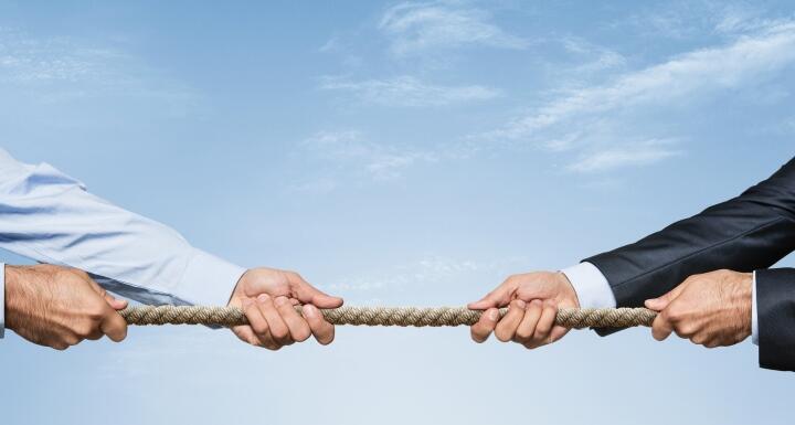 Business people tug of war with rope