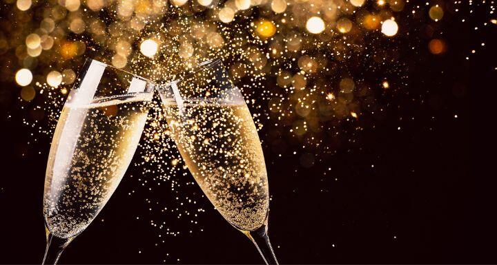 Two glasses of champagne toasting in the night with lights bokeh