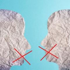 two silhouette faces looak at each other  with red cross over mouth