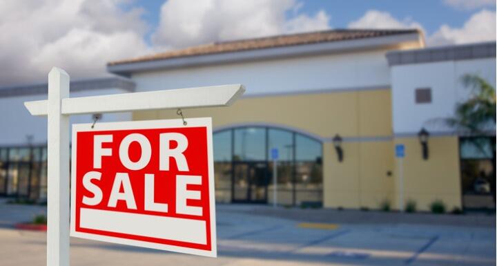 Vacant Retail Building with For Sale Real Estate Sign