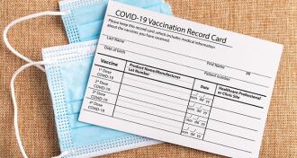 Image of a vaccine card on top of a facemask