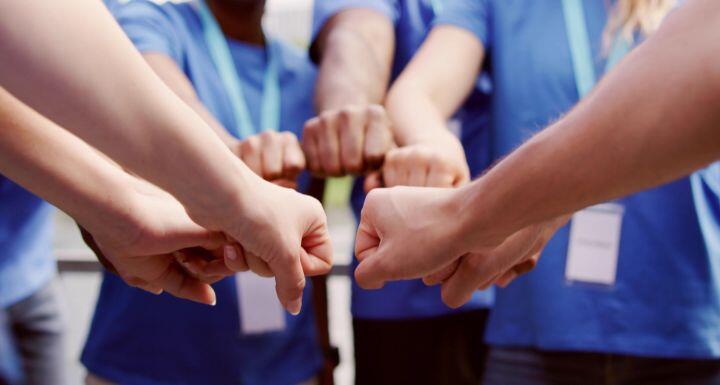 A group of volunteers joing hands in a circle