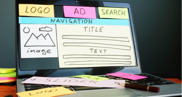 Laptop screen with sticky notes used to layout a website design