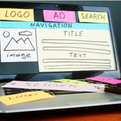 Laptop screen with sticky notes used to layout a website design