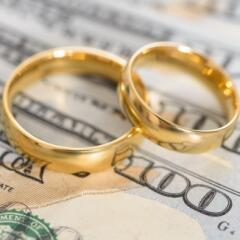 Two wedding bands on hundred dollar bills
