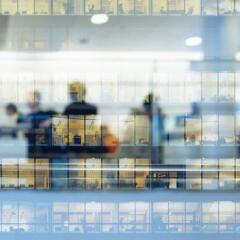 Workers working late. Tall building reflected