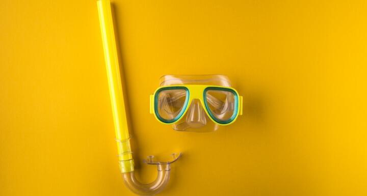 Yellow snorkeling mask on yellow background