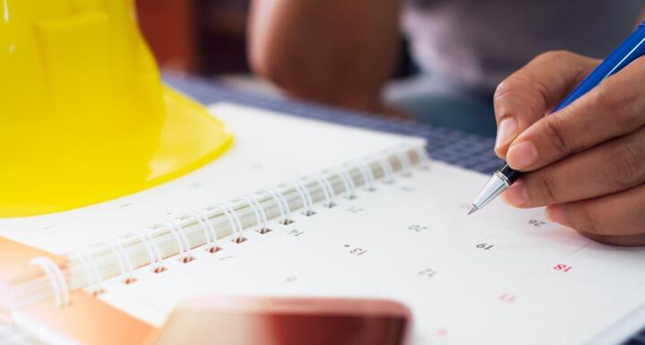 Yellow hard hat and calendar for planning