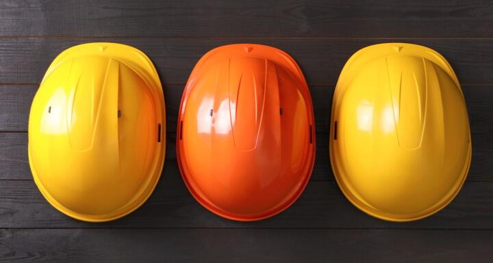 Yellow hard hats and orange hard hat on table