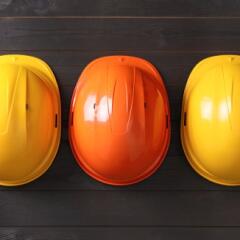 Yellow hard hats and orange hard hat on table