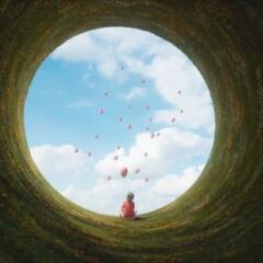 Young boy sitting in fantasy landscape 