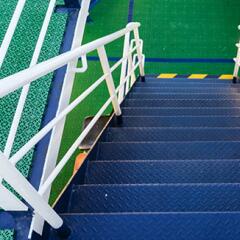 Blue staircase with white railing and green landing