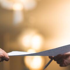 man handing sheet of paper to another person