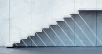White floating cement staircase against a cement wall