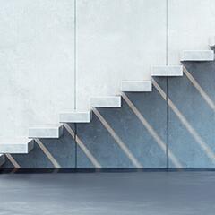 White floating cement staircase against a cement wall