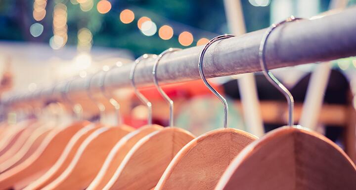 Close up of wooden hangers hanging on metal rod