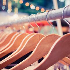Close up of wooden hangers hanging on metal rod