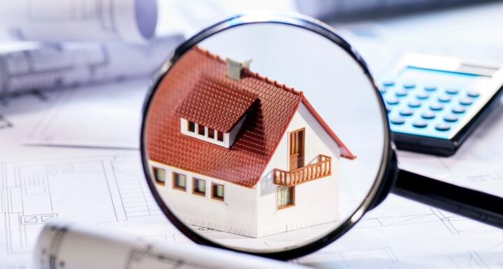 Magnifying glass hovering over house