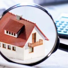 Magnifying glass hovering over house
