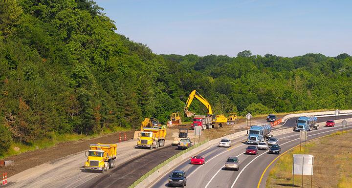 Highway construction with cars, trucks, and equipment