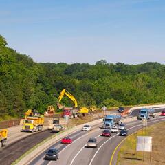 Highway construction with cars, trucks, and equipment