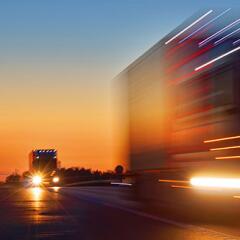 Headlights of big rig truck driving down the highway at dusk