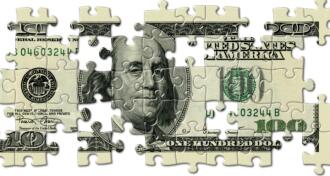 One hundred dollar bill cut into puzzle pieces with several of the pieces missing